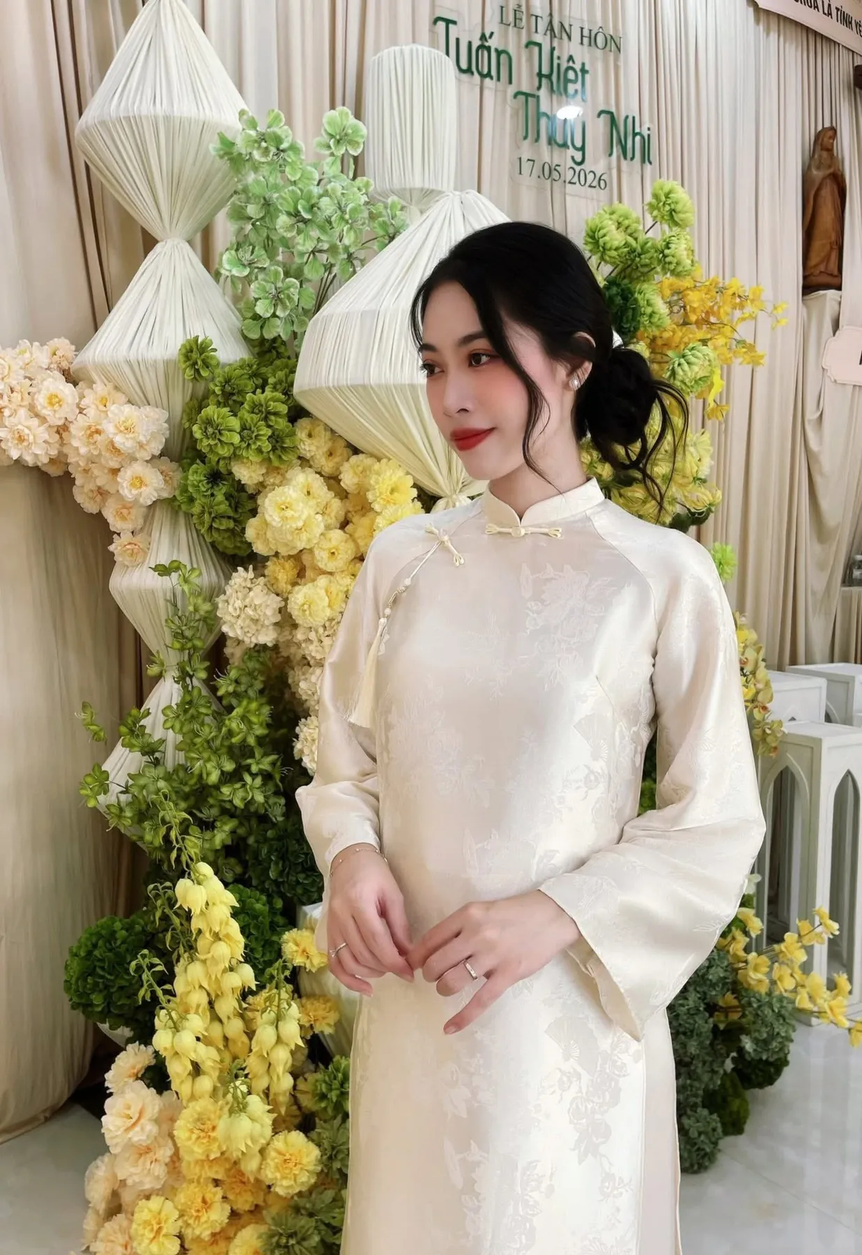 Bạch Quyên trong áo dài trắng bên bàn hoa lễ tân hôn